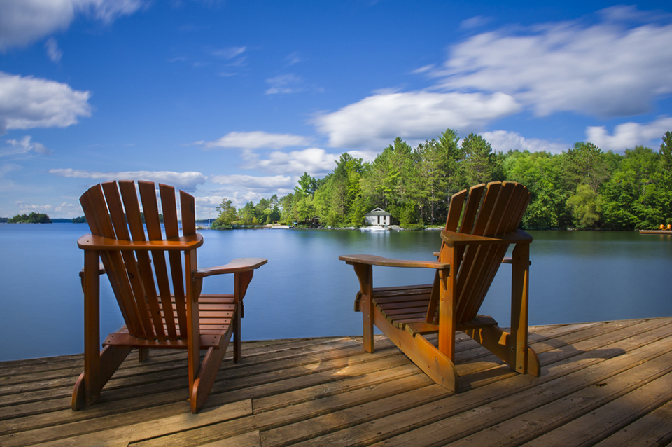Lakefront cottage in Ontario surrounded by trees at dusk, representing cottage owner insurance coverage