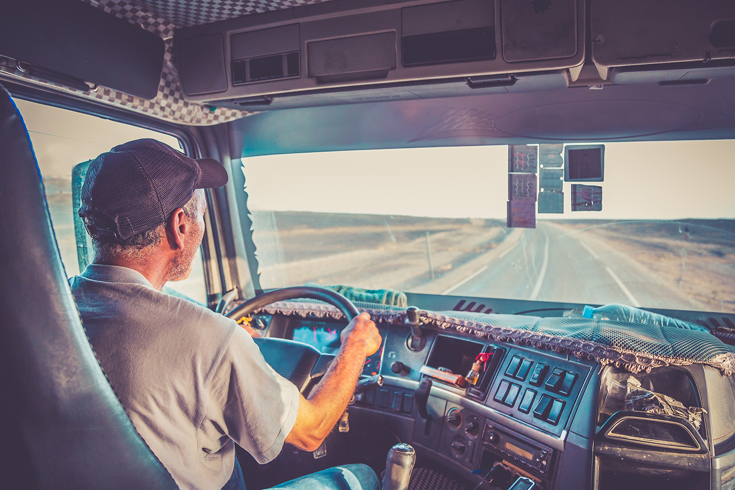 Commercial truck driver on the road in Ontario behind the wheel of a tractor trailer, risk and comprehensive trucking insurance