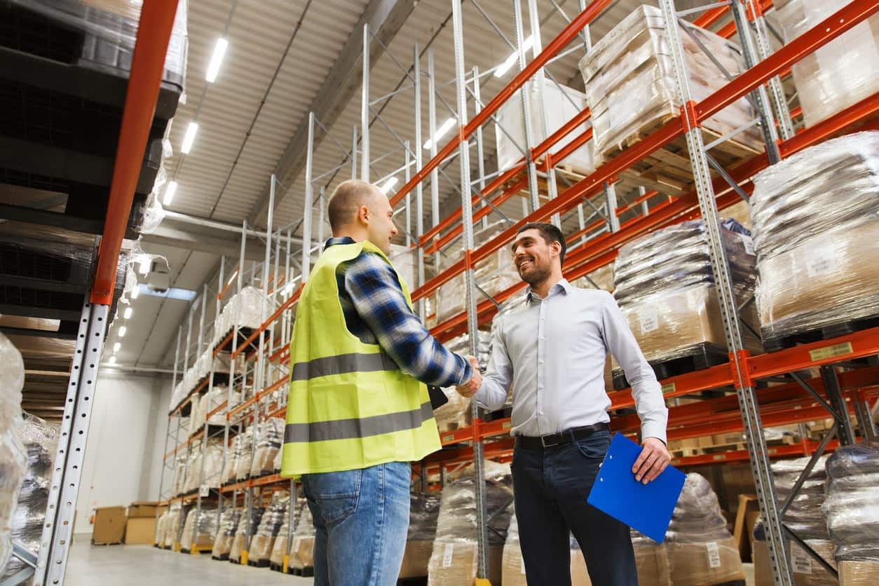 Warehouse manager in Ontario examining inventory in a wholesale distribution facility, illustrating stock & product liability concerns.